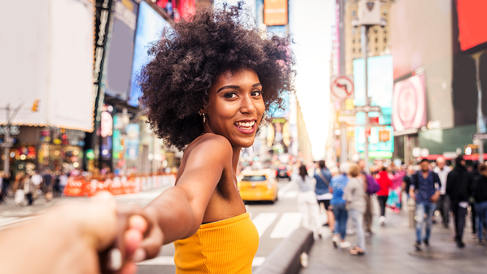 Our local guide Kelly is reaching out to help a tourist on a busy street in Times Square, NYC